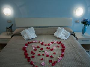 a heart made out of rose petals on a bed at Residence Art in Rimini