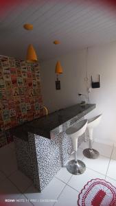 uma cozinha com um balcão e bancos num quarto em Studio Aconchegante em Palmas
