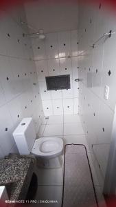 a bathroom with a white toilet in a room at Studio Aconchegante in Palmas
