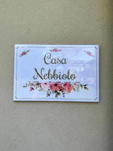 ein Schild an der Wand mit Blumen drauf in der Unterkunft Just Langhe Casa Nebbiolo in Novello
