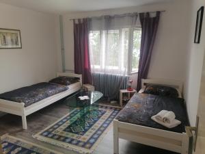 een kamer met 2 bedden en een glazen tafel bij Mujo Z in Sarajevo