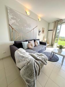 ein Wohnzimmer mit einem Sofa und einer Decke in der Unterkunft Just Langhe Casa Nebbiolo in Novello