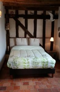 a bedroom with a bed in a room with wooden ceilings at A la Bonne Franquette in Droyes