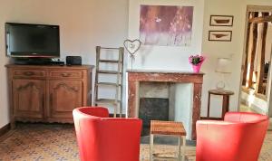 a living room with red chairs and a fireplace at A la Bonne Franquette in Droyes