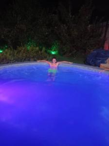 a man in a swimming pool at night at Дача in Vorontsovskoye