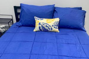 Cama azul con sábanas azules y almohada amarilla en Lincoln Park 3 BR Penthouse en Chicago