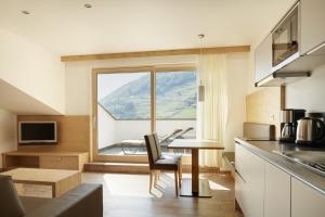 a kitchen with a table and a large window at Apartments Oberdorner in Lagundo