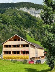 a large building with cars parked in front of a mountain at Apartment Eiler - Mellau in Mellau