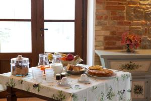 una mesa con un mantel blanco con comida. en Collerovere Country House, en SantʼAngelo in Pontano