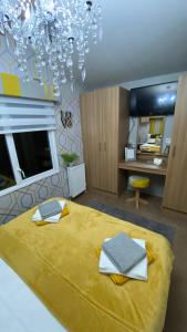 Un dormitorio con una gran cama amarilla con una lámpara de araña en Sandylands Holiday Home en Stevenston