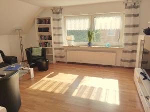 ein Wohnzimmer mit einem großen Fenster und einem Schreibtisch in der Unterkunft Ferienwohnung am See, Hage / Norddeich in Hage