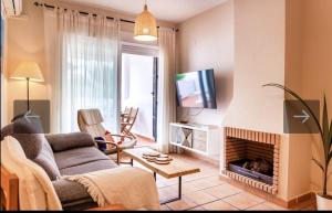 Una sala de estar con un sofá y una chimenea. en Islantilla golf playa, en Huelva