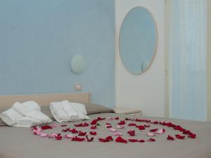 里米尼的住宿－藝術公寓酒店，躺在床上的一束玫瑰
