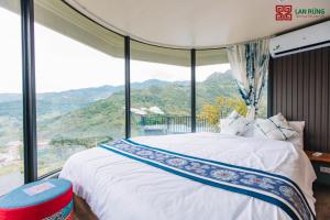 a bedroom with a bed and a large window at Lan Rung Brocade Hotel in Sa Pa