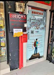 un frente de tienda con un cartel en la ventana de una tienda en BRICKS Backpackers Sleepbox, en Tanah Rata