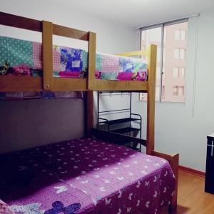 - une chambre avec 2 lits superposés et un lit violet dans l'établissement D'Rous, à Lima