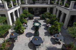 eine Außenterrasse mit Tischen und Stühlen im Innenhof in der Unterkunft Hôtel & SPA Napoléon in Fontainebleau