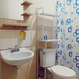 La salle de bains est pourvue d'un lavabo, de toilettes et d'un rideau de douche. dans l'établissement D'Rous, à Lima