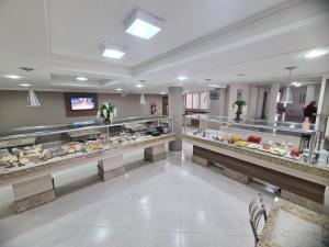a bakery aisle with a lot of food on display at San Marino Palace Hotel in Guarapuava