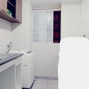 une cuisine blanche avec un évier et une fenêtre dans l'établissement D'Rous, à Lima