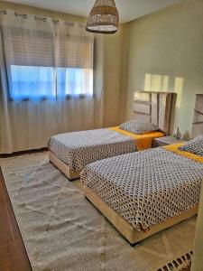 een kamer met 2 bedden in een kamer bij appartement moderne au style beldi résidence au centre de Marrakech avec piscine in Marrakesh