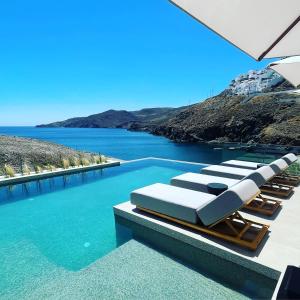 Livadi AstypalaiasにあるAnassa Boutique Hotelの海の景色を望むプール(ラウンジチェア付)