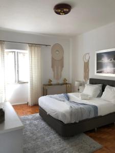 Un dormitorio con una cama grande en una habitación. en Casa da Tina Conforto Familiar no Sítio da Nazaré, en Nazaré