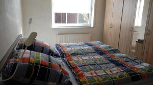 a bedroom with a bed with a quilt on it at Am Reichelbach schöne Natur kostenlose Stellplätze in Neuwied