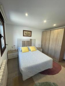 una camera da letto con un grande letto con due cuscini gialli di Casa O Castaño a O Carballiño