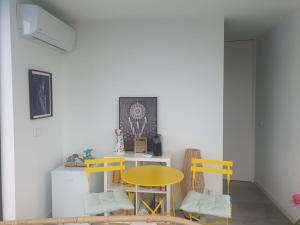 a dining room with a yellow table and two chairs at Space Zen in Valença