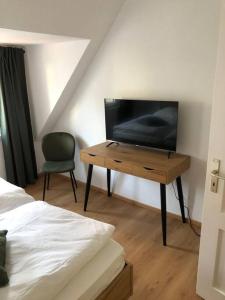 1 dormitorio con TV y escritorio con silla en 2 Zimmer Wohnung in Giessen-Mitte en Gießen