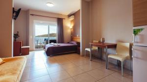una camera d'albergo con letto, tavolo e scrivania di Hotel Apanema a Vivári
