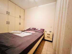niewielka sypialnia z łóżkiem i komodą w obiekcie Good apartment 2 bedroom w mieście Bat Jam