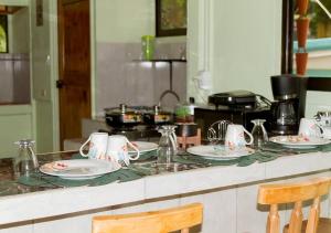 un bancone della cucina con piatti e tazze sopra di Casita Colorada, Sierpe de Osa a Sierpe