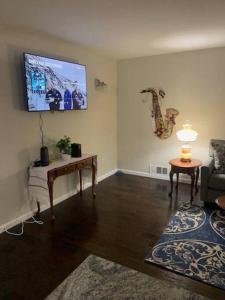 a living room with a couch and a tv on the wall at Cute house in quiet neighborhood in Saginaw