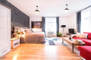a bedroom with a bed and a couch at STING Boutique Apartments in Ostrava