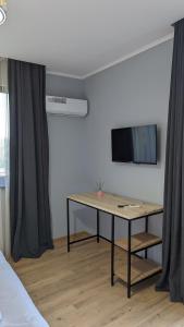 una camera con tavolo e televisore a parete di Jays a Kutaisi