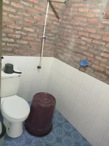 a bathroom with a toilet and a brick wall at Thousand hills ketambe in Lhokuenam