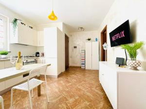 Manziana的住宿－[La Casina Del Colle] Confort,Centrale,P. Gratuito.，厨房配有白色橱柜和桌椅
