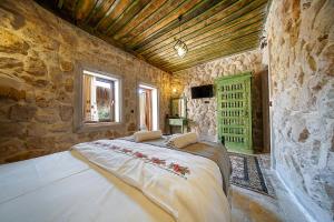 a bedroom with a large bed in a stone wall at Aysel Inn House in Avcılar