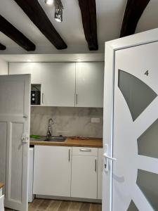 a kitchen with white cabinets and a sink at Belle F2 centre ville Massy avec jardin in Massy