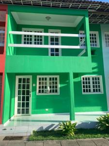 un bâtiment vert avec des fenêtres blanches sur une rue dans l'établissement Casa Duplex Maria Farinha, à Paulista