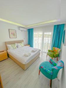 - une chambre avec un lit et deux chaises dans l'établissement Mercan Otel, à Çanakkale