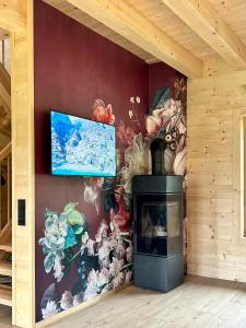 uma lareira num quarto com uma pintura na parede em Das Grünhaus - Dein Chalet in Grünau im Almtal em Grünau im Almtal