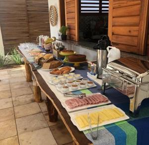 une longue table avec différents types de denrées alimentaires dans l'établissement POUSADA VILLA SOLEIL icaraizinho, à Icaraí