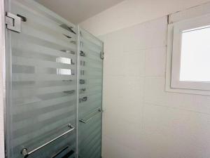 a shower with a glass door in a bathroom at Great 2 BR apartment view to the garden in Bat Yam