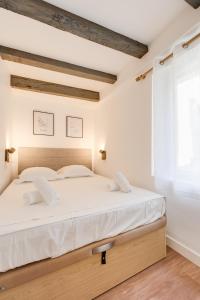 um quarto com uma cama grande e lençóis brancos em L'Escale bleue em Annecy