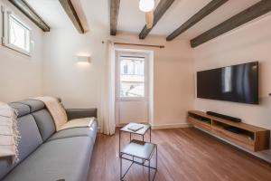 un salon avec un canapé et une télévision à écran plat dans l'établissement L'Escale bleue, à Annecy