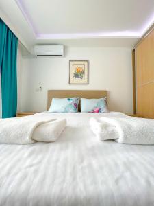 un grande letto bianco con due cuscini sopra di Mercan Otel a Çanakkale