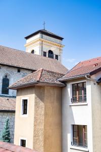 un bâtiment avec une tour d'horloge en arrière-plan dans l'établissement L'Escale bleue, à Annecy